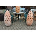 A large pair of terracotta garden floor standing lanterns with pierced star shaped decoration.