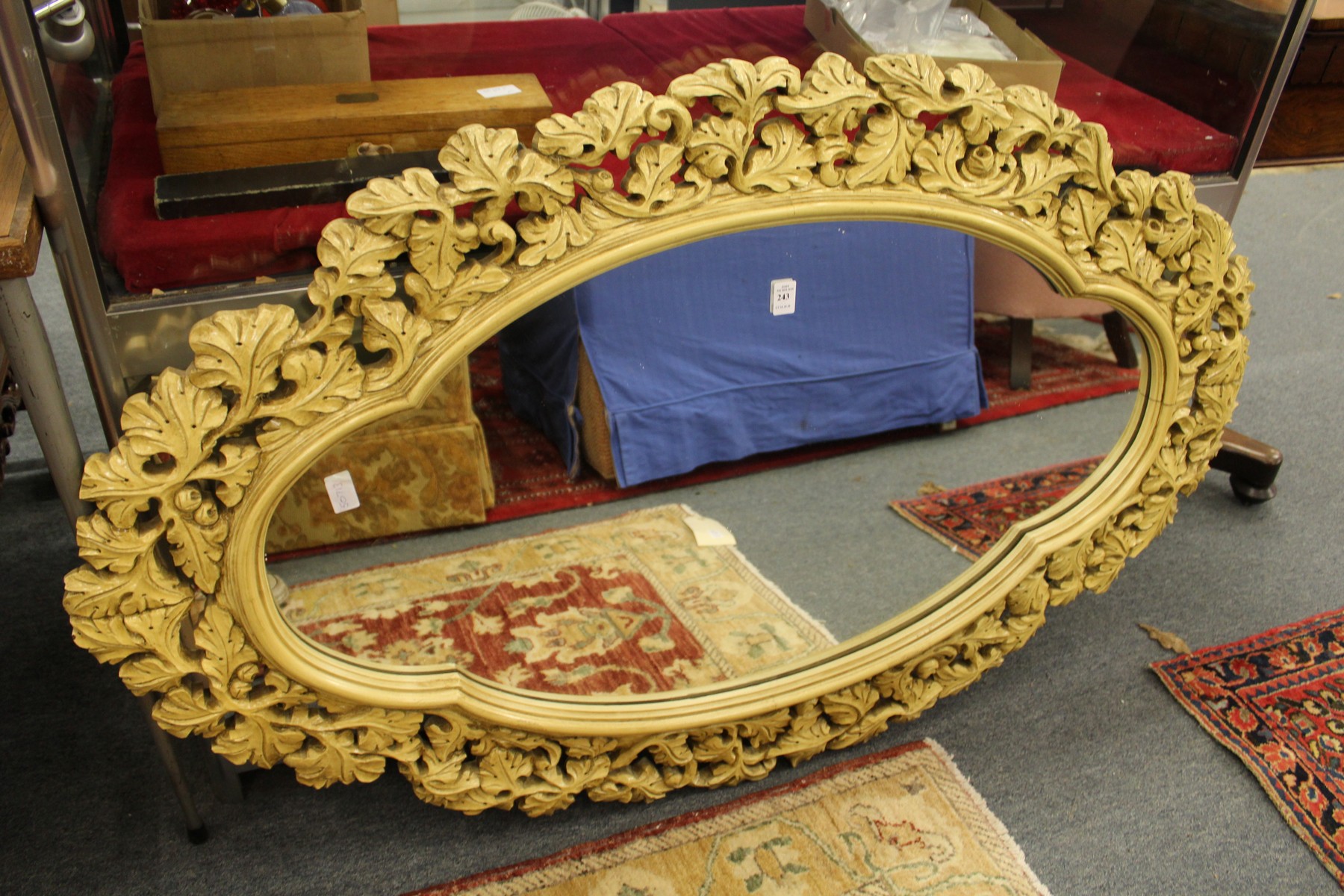 A decorative mirror with painted and carved wood frame.