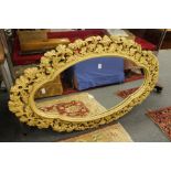 A decorative mirror with painted and carved wood frame.