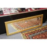 A modern rectangular gilt framed wall mirror.