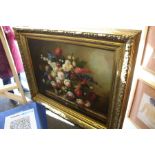 A still life of flowers in a vase on a ledge, oil on canvas, in a large decorative gilt frame.