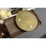 An eastern brass circular tray and two carved wood trays.