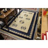 A Chinese rug, beige ground with eight floral motifs.