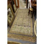 A Persian beige ground rug with stylized decoration.