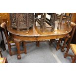 A mahogany extending dining table with one leaf on carved cabriole legs with claw and ball feet.