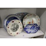 A blue and white circular plate depicting Doctor Syntax, a nursery plate and three other items.