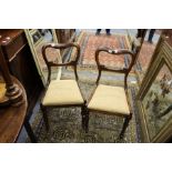 A pair of Victorian rosewood dining chairs with kidney backs, drop-in seats on turned and carved