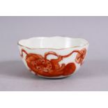 A 19TH / 20TH CENTURY CHINESE IRON RED PORCELAIN WINE CUP, decorated with lion dogs playing, the