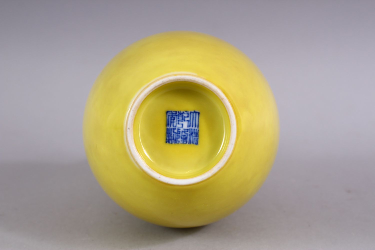 A CHINESE YELLOW GROUND MONOCHROME PORCELAIN BOTTLE VASE, the base with a six character mark, 22cm. - Image 2 of 3