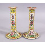 A PAIR OF 19TH CENTURY CHINESE CANTON FAMILLE JAUNE / ROSE CANDLESTICKS, decorated with panels of