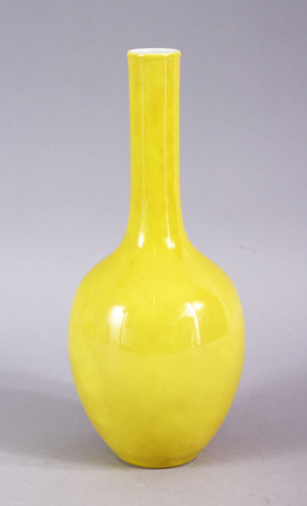 A CHINESE YELLOW GROUND MONOCHROME PORCELAIN BOTTLE VASE, the base with a six character mark, 22cm.