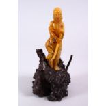 A CHINESE CARVED NATURAL SOAPSTONE FIGURE OF LUOHAN ON STAND, the figure well carved depicting