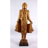 A LARGE INDIAN GILT WOOD INLAID FIGURE OF A DEITY, stood in an elegant pose in traditional gowns,