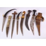 A COLLECTION OF 6 ISLAMIC AND TRIBAL DAGGERS - one with a carved bone sheath, some decorated