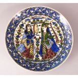 A LARGE 19TH CENTURY PERSIAN QAJAR GLAZED POTTERY CHARGER, with two figures in landscapes, 33cm