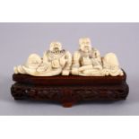 AN EARLY 20TH CENTURY CHINESE CARVED IVORY FIGURE OF TWO DRINKING MEN, both men seated drinking from