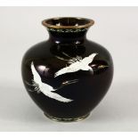 A JAPANESE MEIJI PERIOD BLACK GROUND CLOISONNE VASE, the black ground depicting three flying cranes,