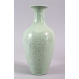 A CHINESE CELADON PORCELAIN CARVED VASE, decorated with borders of Ruyi with roundel of chiilong,