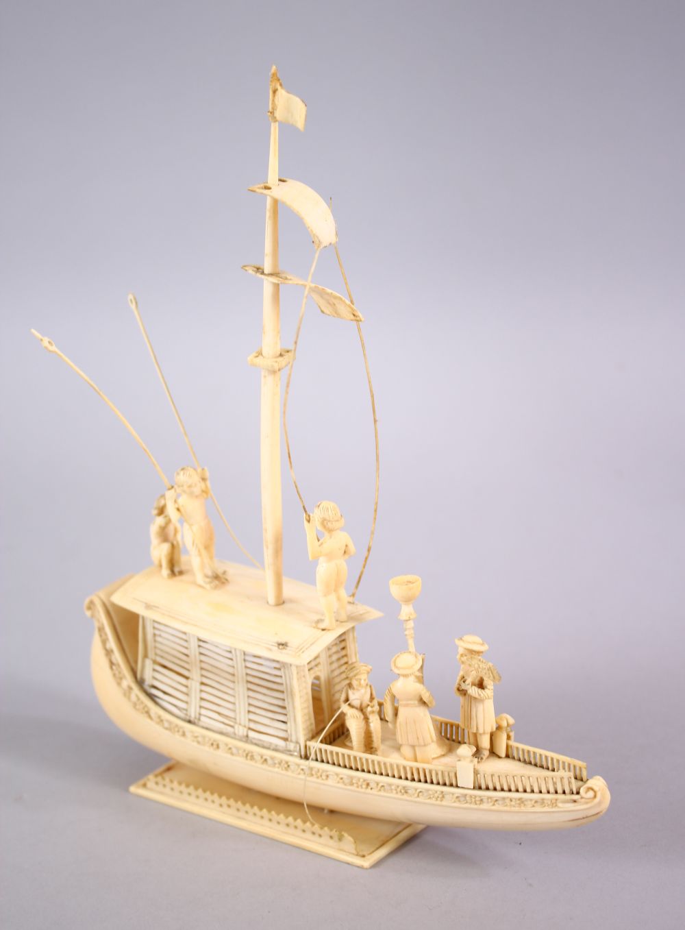 A FINELY CARVED 19TH CENTURY INDIAN IVORY BOAT WITH FISHERMEN, with fine strands of sails, six