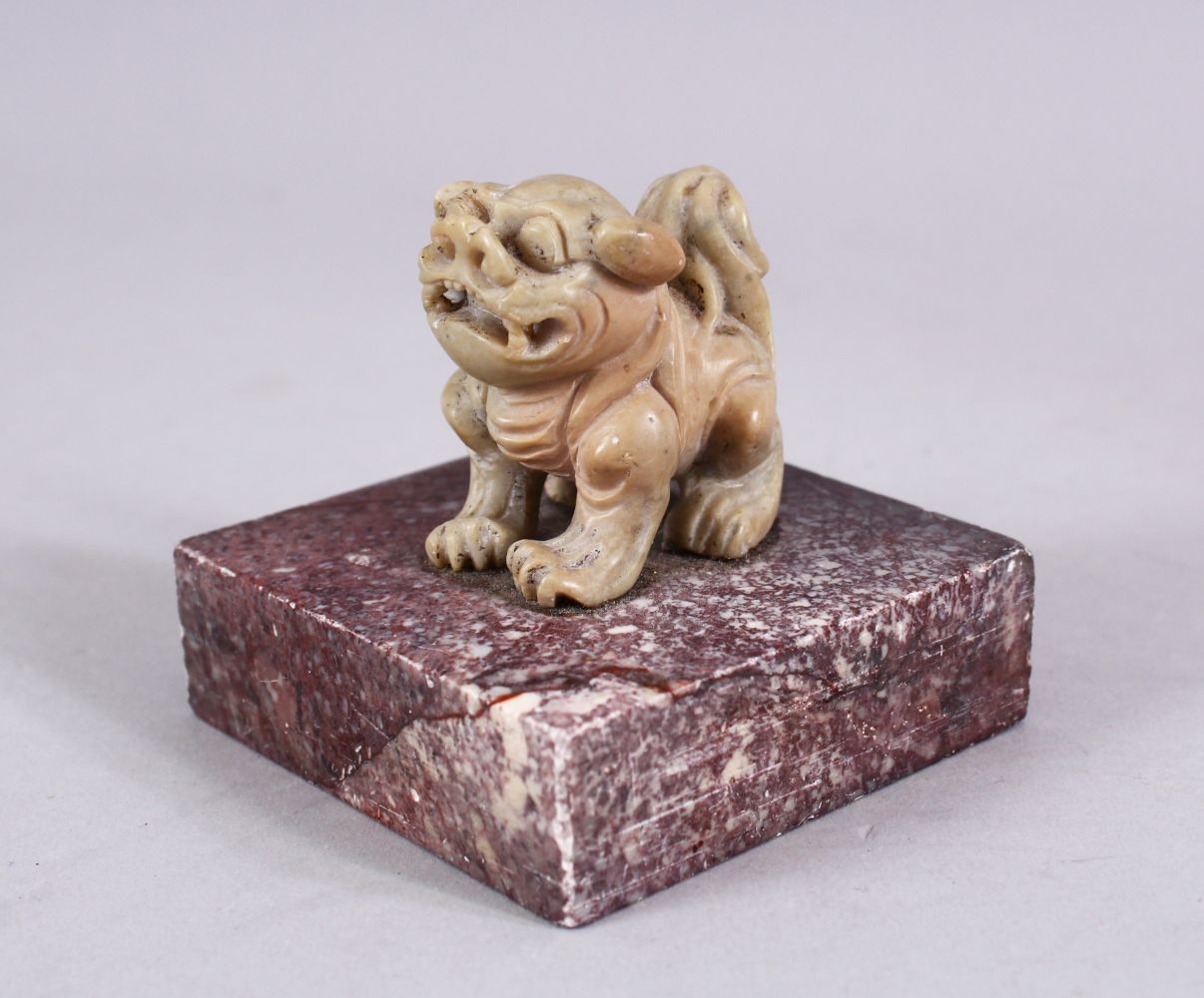 A CHINESE 19TH / 20TH CENTURY CARVED SOAPSTONE LION DOG SEAL, the dog upon plinth, the base cared