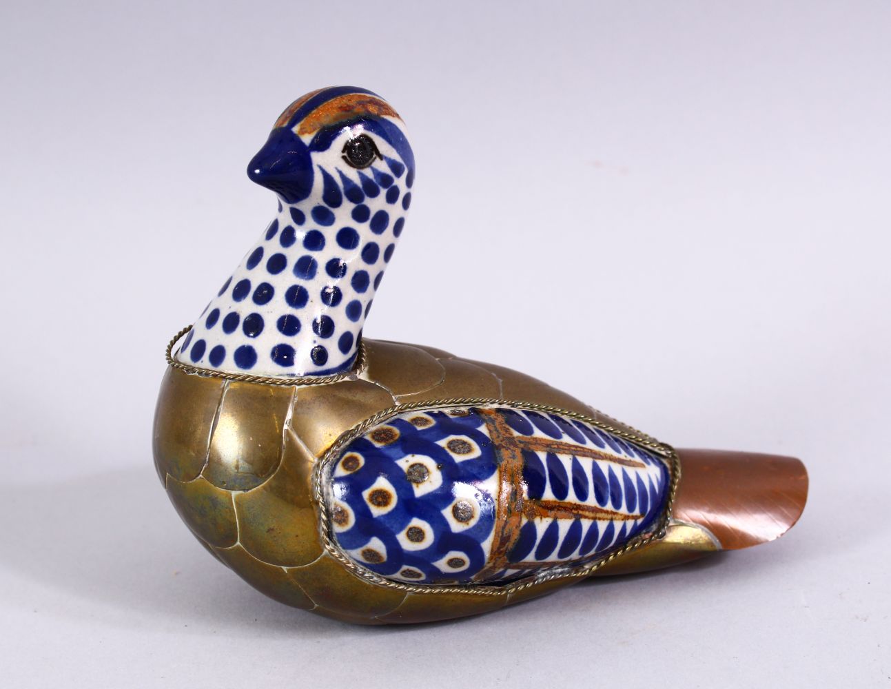 A GOOD ISLAMIC PORCELAIN AND METAL BOUND FIGURE OF A BIRD, the porcelain panels with blue brown