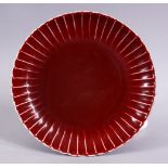 A CHINESE MING STYLE COPPER RED PORCELAIN RIBBED DISH, 21.5cm the base with a six character mark.
