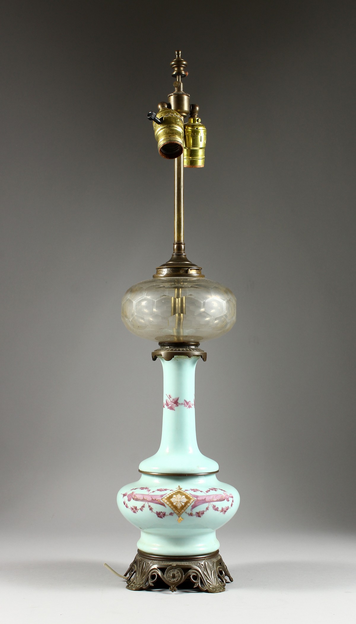 A VICTORIAN OPALINE LAMP with glass reservoir and metal mounts. 26ins high overall.