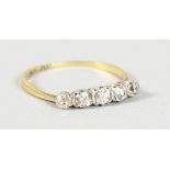 AN 18CT GOLD FIVE STONE DIAMOND RING.