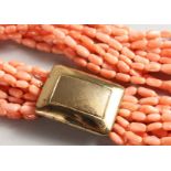 A TWELVE STRAND CORAL AND BEAD NECKLACE with 14ct gold clasp. 20ins long.