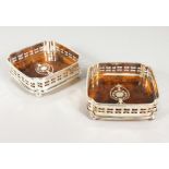 A PAIR OF SILVER PLATE AND FAUX TORTOISESHELL COASTERS. 5ins wide.