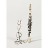 A MINIATURE SILVER CLARINET AND STAND.