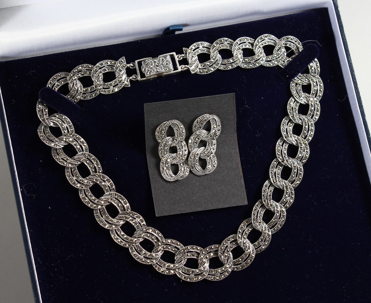 A HEAVY SILVER MARCASITE NECKLACE AND EARRINGS.