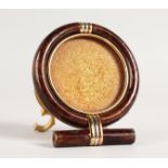 A CARTIER CIRCULAR PHOTOGRAPH FRAME in a bag. 2.75ins diameter.