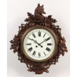 AN ANTIQUE BLACK FOREST CARVED WOOD WALL CLOCK, carved with an animals head, hunting horn and oak