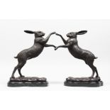 A PAIR OF BRONZE "BOXING HARES" on marble bases. 11.5ins high.