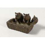 A MINIATURE BRONZE GROUP OF THREE PIGS AT A TROUGH.