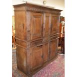 A 17TH CENTURY FOUR DOOR STANDING CUPBOARD, with carved and moulded cornice, central panels