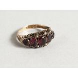 AN 18CT RUBY AND SEED PEARL SET FIVE-STONE RING.