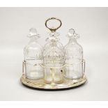 A GOOD GEORGE III OVAL FOUR BOTTLE CRUET, with four decanters and stoppers, the frame with gadrooned