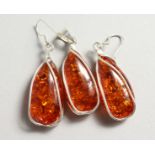 A SILVER AND AMBER PENDANT with a pair of matching earrings.