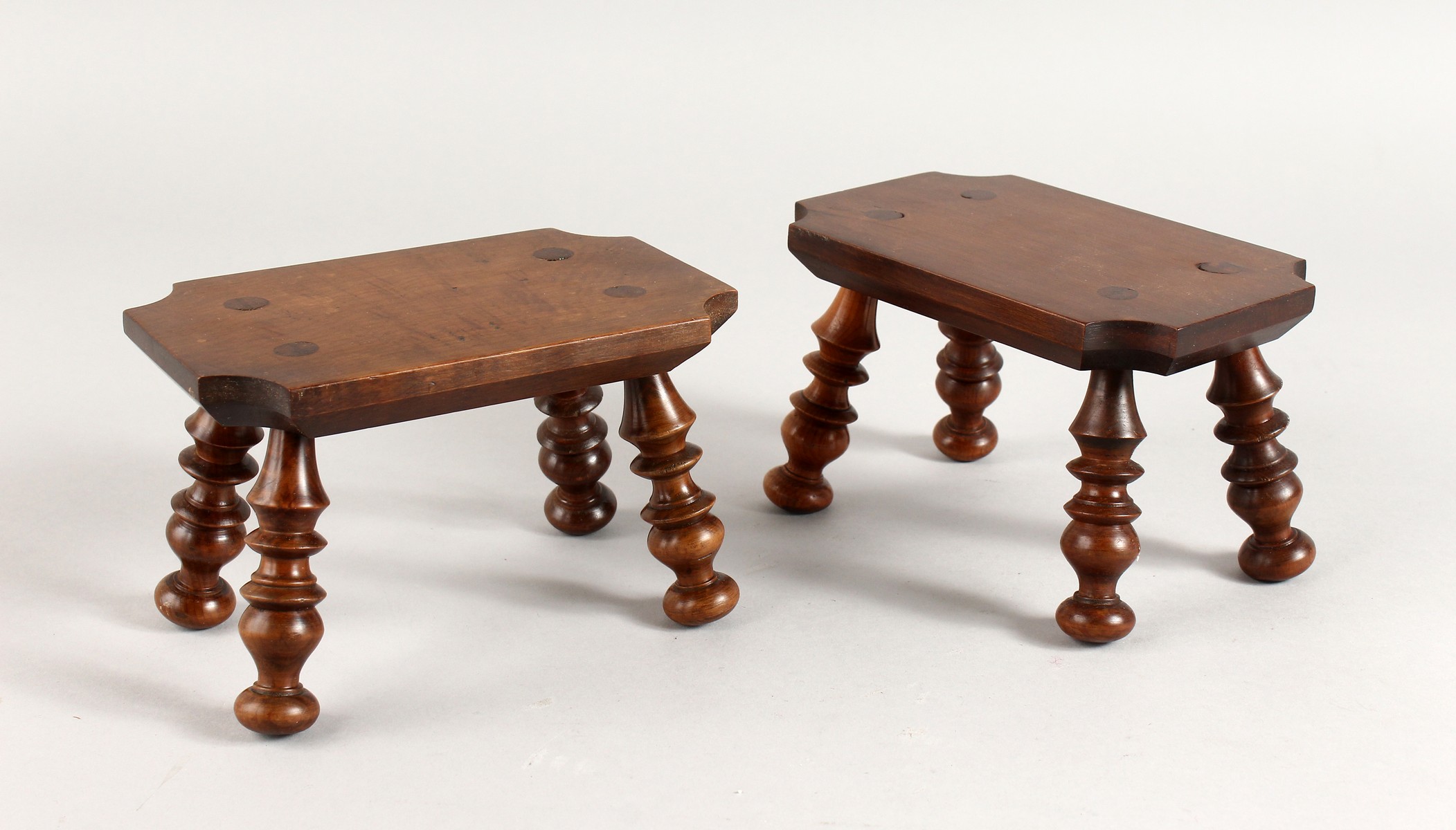 A PAIR OF WOODEN CANDLE STANDS on turned legs. 6ins.