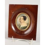 AN OVAL PORTRAIT MINIATURE OF A YOUNG LADY in a wooden frame. 2.75ins x 2ins. Signed.