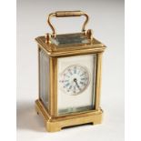 A MINIATURE BRASS CARRIAGE CLOCK with silvered front and Roman numerals. 2.25ins high.