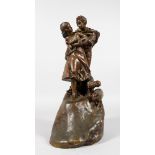 A LATE 19TH CENTURY BRONZE GROUP OF YOUNG LOVERS in an embrace, standing on a hill with sheep at