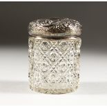 A CUT GLASS DRESSING TABLE JAR, with embossed silver top, Chester 1900. 4ins high.