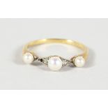 A VICTORIAN GOLD AND TRIPLE PEARL RING.