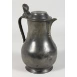 AN EARLY PEWTER LIDDED JUG, stamped MARTIN. 9.5ins high.