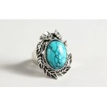 A SILVER AND TURQUOISE RING.