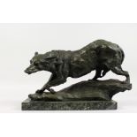 AN ABSTRACT BRONZE OF A PROWLING WOLF, on a marble base. 17ins long.