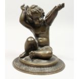 A GOOD BRONZE WINGED CUPID on a circular base. 7ins high.